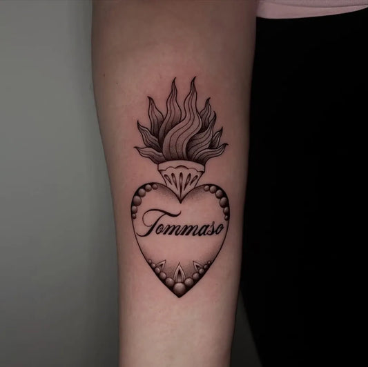 Medium Blackwork Sacred Heart with Flames and Name Tattoo on Women Arm by @eleonorghizzoni_tattoo