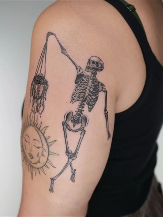 Medium Blackwork Skeleton with Scales and Sun Tattoo on Women Arm by @captainshade.tt
