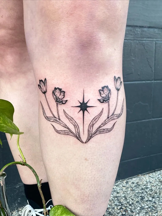 Medium Blackwork Star and Woodcut Tulips Tattoo on Women Thigh by @silly_little_tattooist