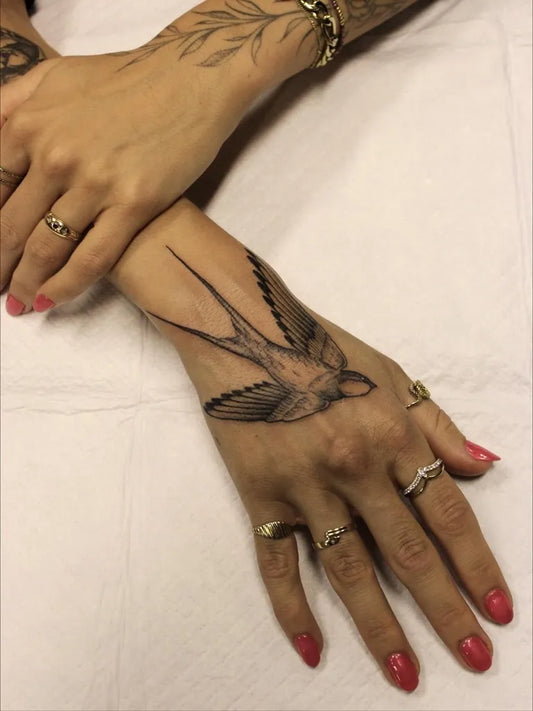Medium Blackwork Swallow Bird Tattoo on Women Wrist by @pacolettering