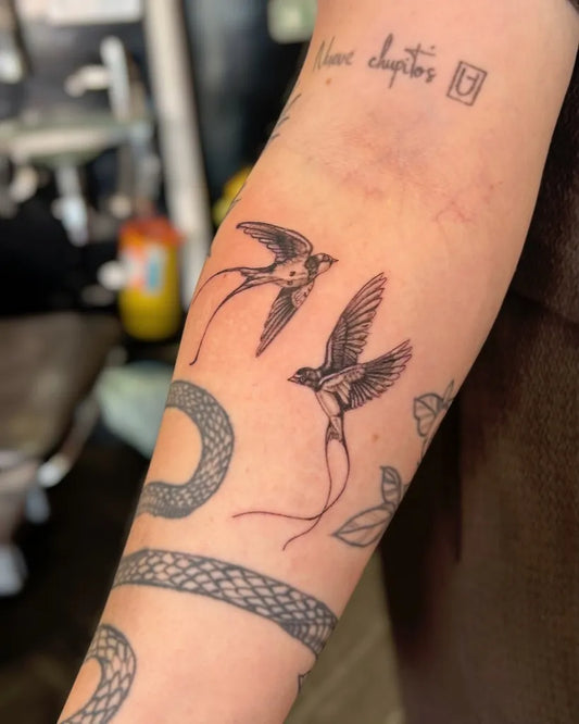 Medium Blackwork Swallow and Snake Tattoo on Women Arm by @wolfesstattoos