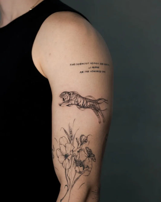 Medium Blackwork Tiger and Flowers Tattoo on Men Bicep by @cristinasantats