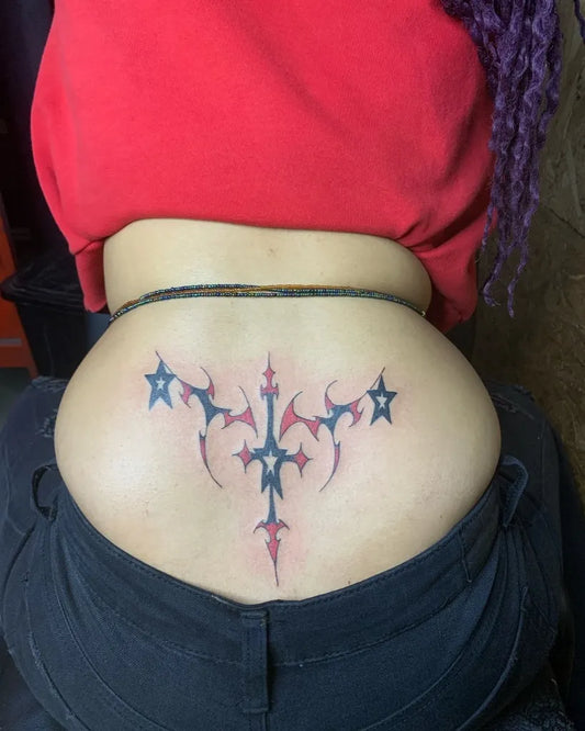 Medium Blackwork Tribal Cross and Stars Tattoo on Women Lower Back by @hydra_tattoos