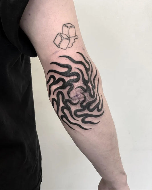 Medium Blackwork Tribal Flame and Ice Cube Tattoo on Men Elbow by @yellowblade.ttt