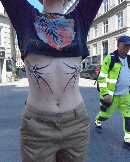 Medium Blackwork Tribal Wings Tattoo on Women Stomach by @armin.agne