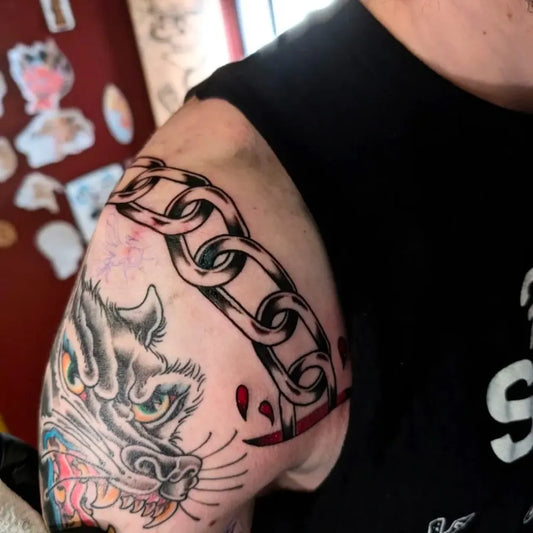 Medium Blackwork Wolf and Chain Tattoo on Men Shoulder by @brasscitytattoo