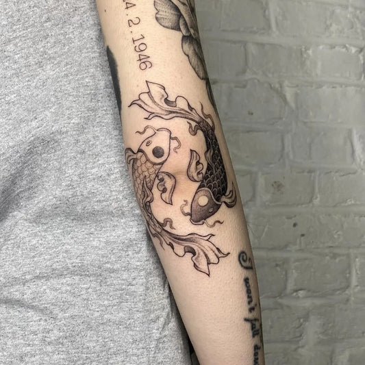 Medium Blackwork Yin Yang Koi Tattoo on Women Arm by @lauragascoynee_tattoo