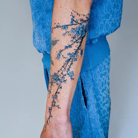 Medium Blue Blueberry Branch Tattoo on Women Arm by @tattooist.yup