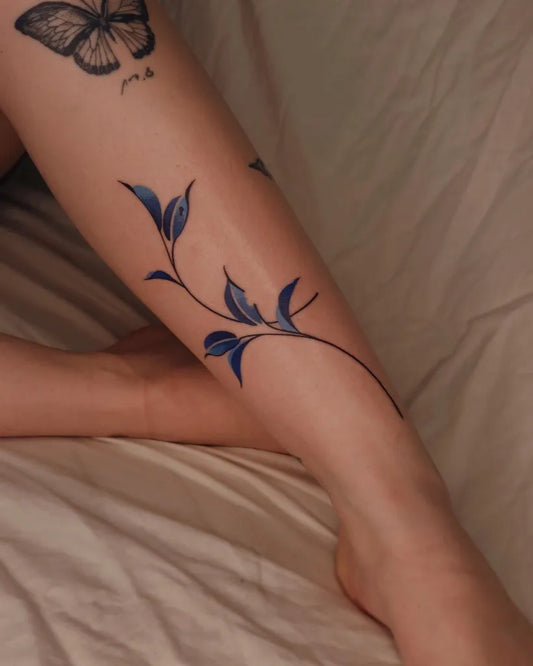 Medium Blue Butterfly and Leaves Tattoo on Women Leg by @xinbi.tattoo_