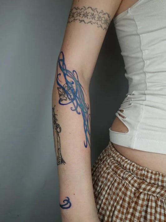 Medium Blue Butterfly and Vines Tattoo on Women Arm by @teaglitch