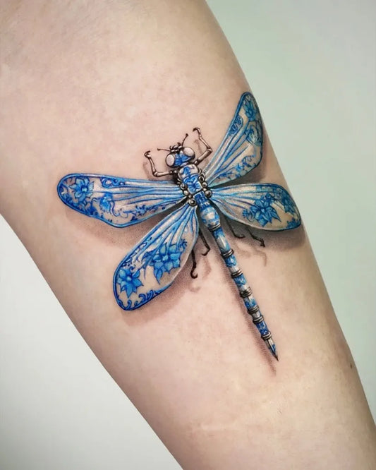 Medium Blue Porcelain Dragonfly on Women Arm Tattoo by @369.inkstudio