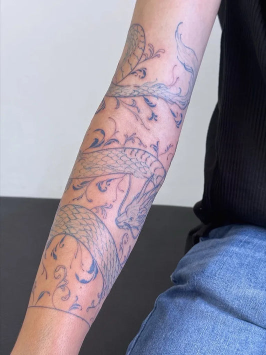 Medium Blue Snake with Floral Vines Tattoo on Women Arm by @la__japo