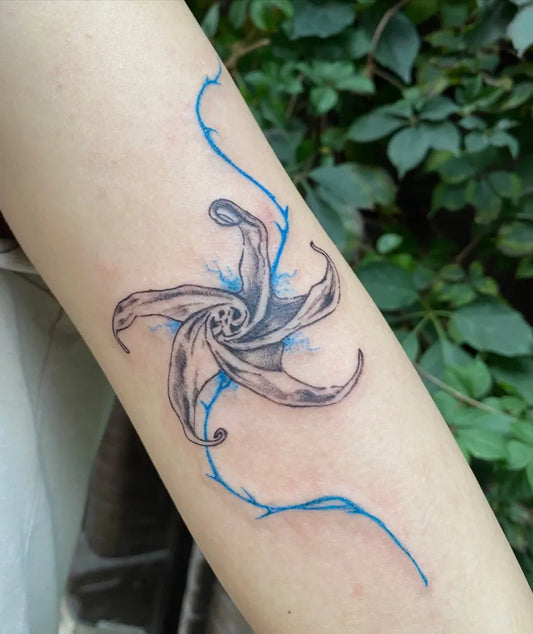 Medium Blue StarLilyTattoo on Women Arm by @bla.inkk