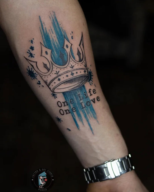 Medium Blue Watercolor Crown with Blue Splashes Tattoo on Men Arm by @tattoo_art_picasso