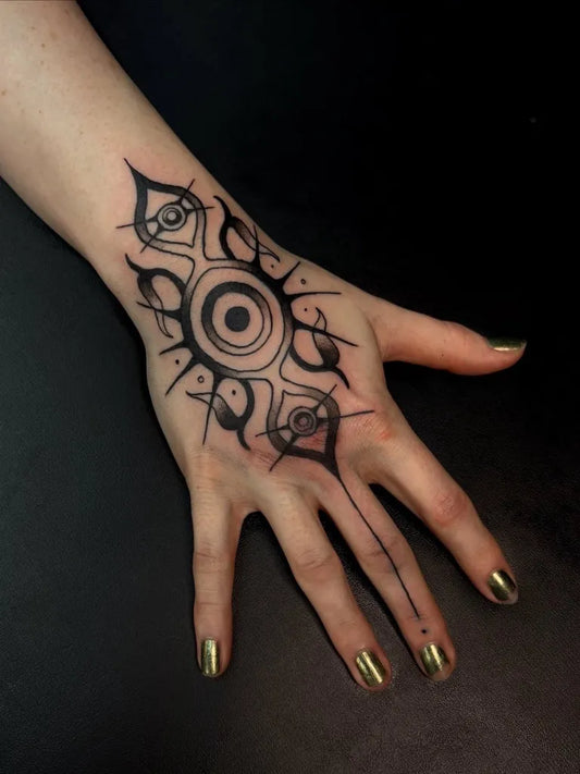 Medium Celtic Eye and Tribal Ornaments Tattoo on Women Wrist by @noodledead.ink