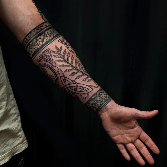 Medium Celtic Knot Band and Foliage Tattoo on Men Arm by @thenordictattoo