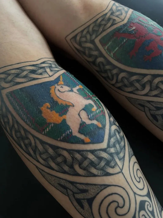 Medium Celtic Shield with Unicorn and Lion Tattoo on Women Leg by @celtictattooer