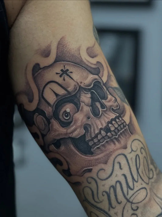 Medium Chicano Skull with Smile Tattoo on Men Arm by @jgilestattoo
