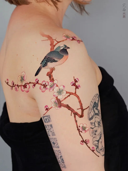 Medium Chinese Bird Blossom Branch Tattoo on Women Shoulder by @tattoo.vinc
