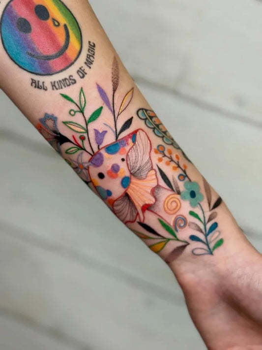 Medium Colorful SmilingRainbowFace Fish Flowers Tattoo on Women Arm by @muridiana