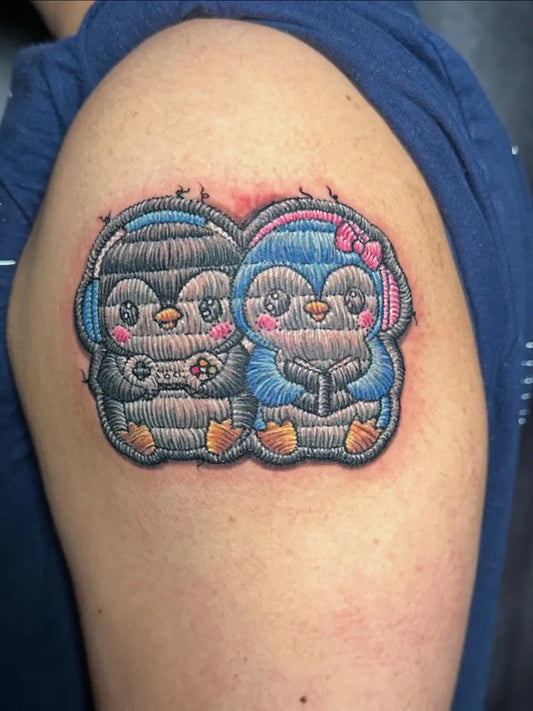 Medium Embroidery Couple of Cute Penguins with Headphones Tattoo on Women Upper Arm by @phantastic_tattoos