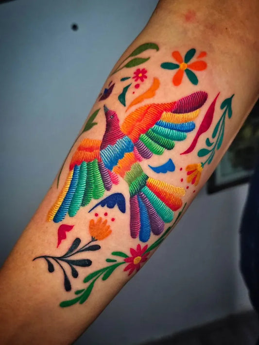 Medium Embroidery Hummingbird with Flowers and Vines Tattoo on Women Arm by @indigotatuaje