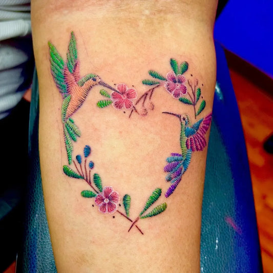 Medium Embroidery Hummingbirds Heart Flowers Tattoo on Women Arm by @rootsdeeptattoo