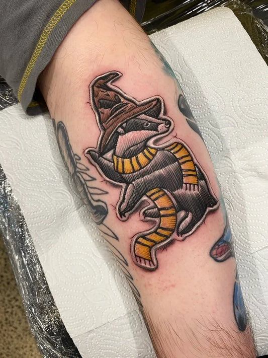Medium Embroidery Raccoon in Hat and Scarf Tattoo on Men Arm by @tylerreneetattoos
