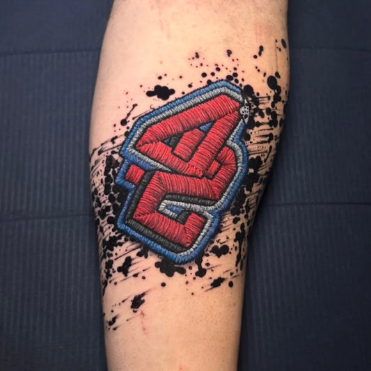 Medium Embroidery Red 42 Logo with Splatter Tattoo on Men Arm by @dudalozanotattoo