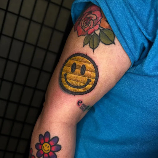 Medium Embroidery Smiley Face Rose Daisy Tattoo on Women Arm by @stonevein.tattoo