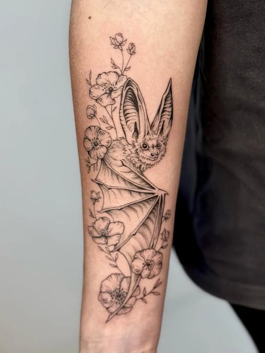 Medium Fine Line Bat and Flowers Tattoo on Women Arm by @ruthfrancestattoo