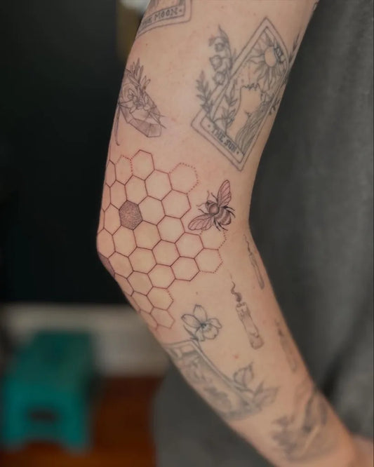 Medium Fine Line Bee Honeycomb Flowers on Women Arm Tattoo by @kaykeez.ink