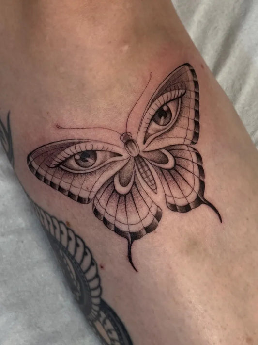 Fine Line Butterfly with Eyes on Women Forearm Tattoo by @iria_alcojor