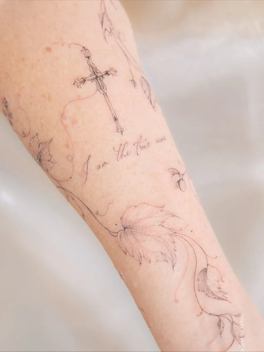 Medium Fine Line Cross with Vines on Women Arm Tattoo by @modelajna