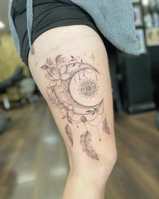 Medium Fine Line Dream Catcher Moon Flowers Tattoo on Women Thigh by @emburdentattoo