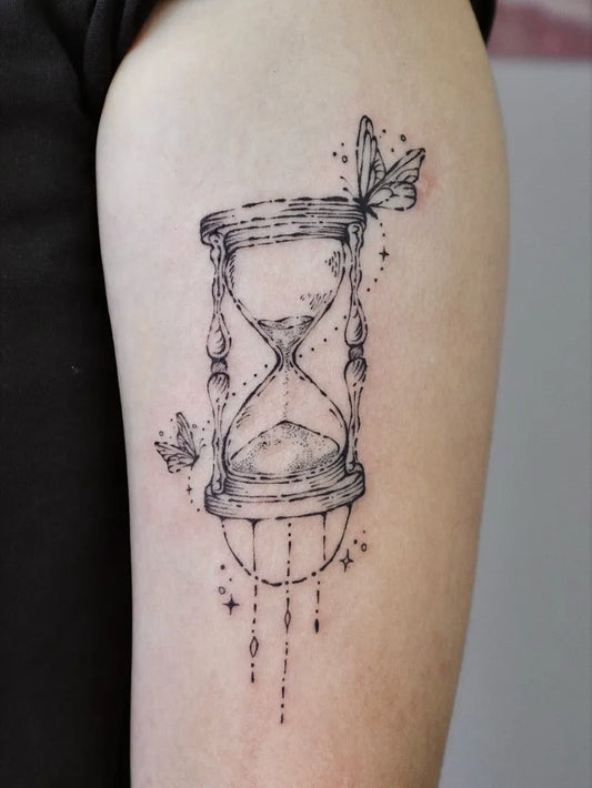 Medium Fine Line Hourglass with Butterfly Tattoo on Women Arm by @geeumtattoo