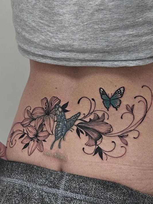 Medium Floral Butterfly and Lilies Tattoo on Women Lower Back by @rosewater_________