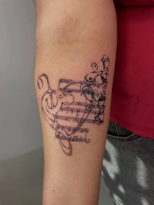 Medium Gothic Musical Notes and Staff Tattoo on Women Arm by @blu.you
