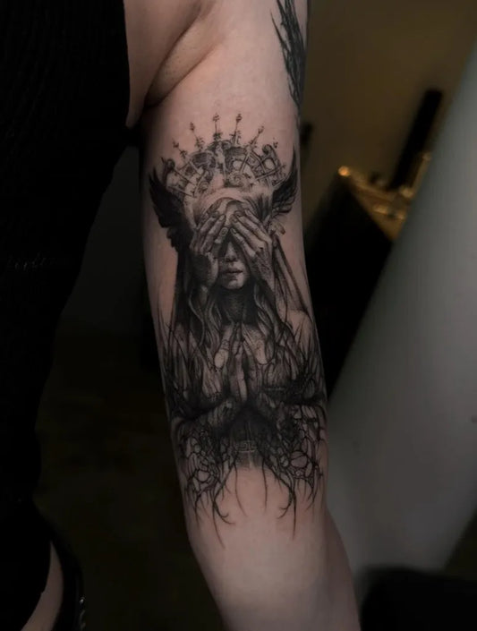 Medium Gothic Woman with Flower Crown Covering Eyes and Rooted Hands Tattoo on Women Arm by @r.grace.tattoo