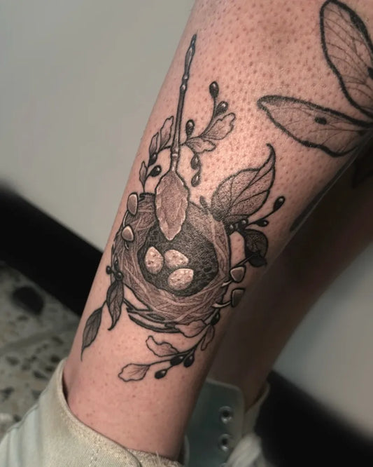 Medium Illustrative Bird Nest With Eggs Tattoo on Women Leg by @emilyhex.tattoo