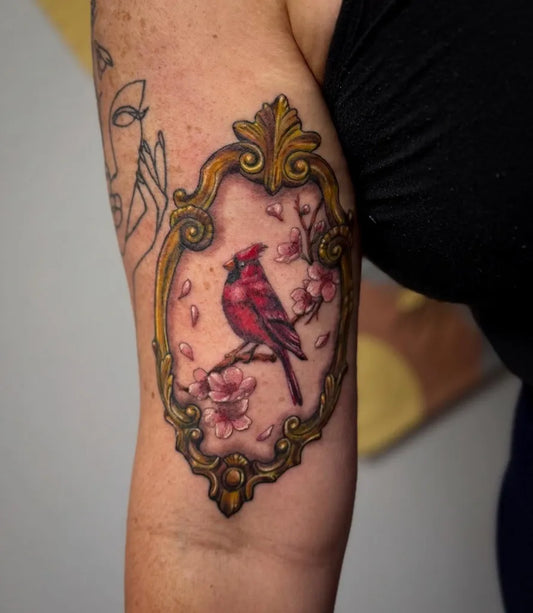 Medium Illustrative Cardinal with Cherry Blossoms and Ornate Frame Tattoo on Women Arm by @ktea_and_tattoos