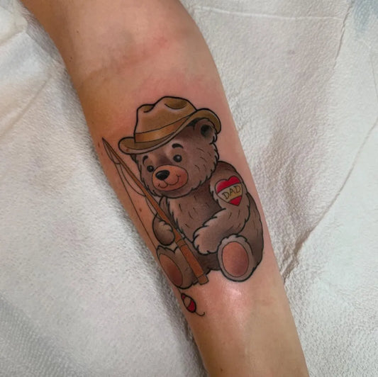 Medium Illustrative Fishing Bear with Hat and Heart on Men Arm Tattoo by @artvandelaytattoos
