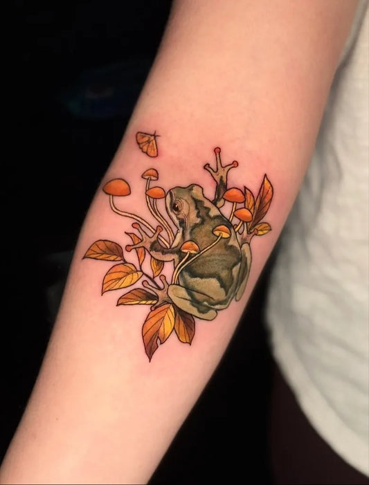 Medium Illustrative Frog Mushrooms Leaves Tattoo on Women Arm by @daughterofmars.tattoos