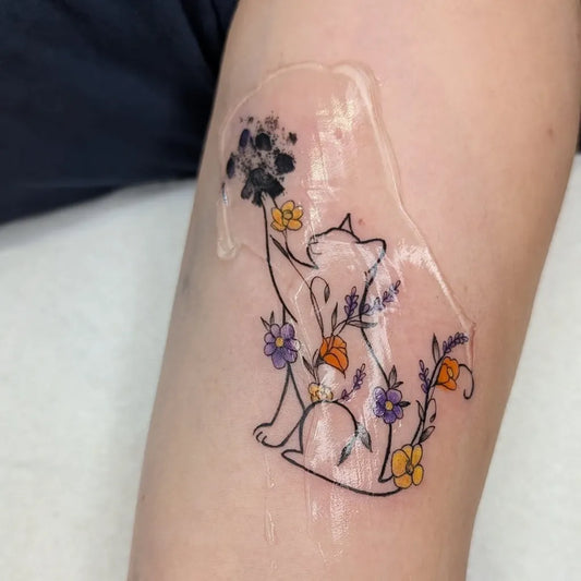 Medium Linework Cat with Flowers Tattoo on Women Forearm by @jodimaitattoos