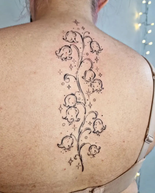 Medium Linework Lily of the Valley with Stars on Women Back Tattoo by @_cloudy.ink_