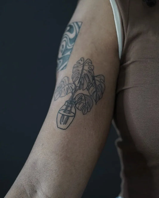 Medium Linework Monstera in Pot on Women Arm Tattoo by @undertheneedle_london