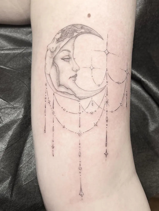 Medium Linework Moon Face Tattoo on Women Arm by @tattoosbyjuliec