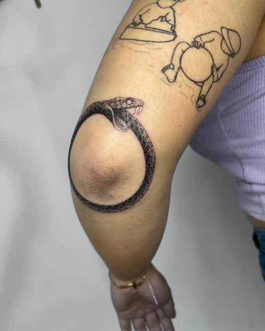 Medium Linework Ouroboros and Figures Tattoo on Women Elbow by @mgstattoo