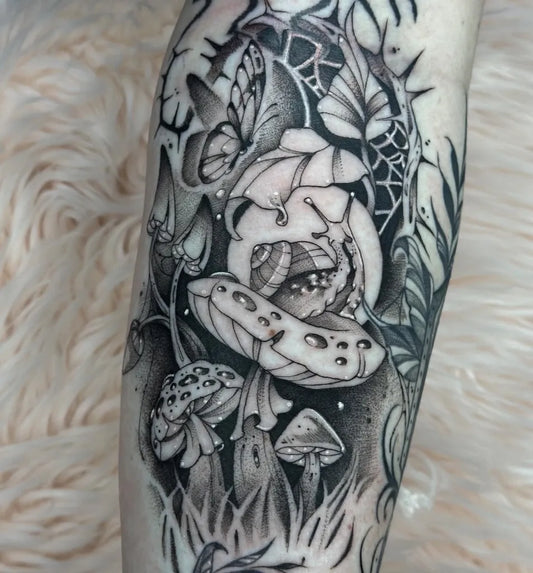 Medium Negative Space Mushroom Flower Butterfly Tattoo on Women Leg by @mezzo.tattoo