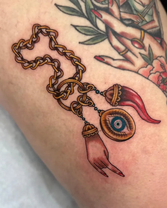 Medium Neo Traditional Evil Eye Chain with Horns and Hand on Women Arm Tattoo by @jessydufourtattoos